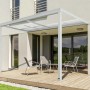 Weiße Home Deluxe Terrassenüberdachung Solis Deluxe mit Schiebedach und Sitzgruppe auf Holzterrasse.