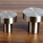Zwei SOTECH Möbelknöpfe EK03 aus gebürstetem Edelstahl auf Holzoberfläche, Ø30 mm.