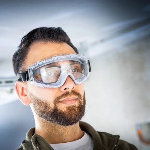 Mann mit LUX-TOOLS Schutzbrille mit Band, Augenschutz für Werkstatt und Baustelle.