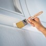 LUX Flachpinsel 80 mm beim Lackieren einer weißen Wand, Holzgriff mit Aufhängeöse.