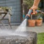 Gardena Comfort Reinigungsspritze ecoPulse™ in Aktion beim Reinigen eines Steins.