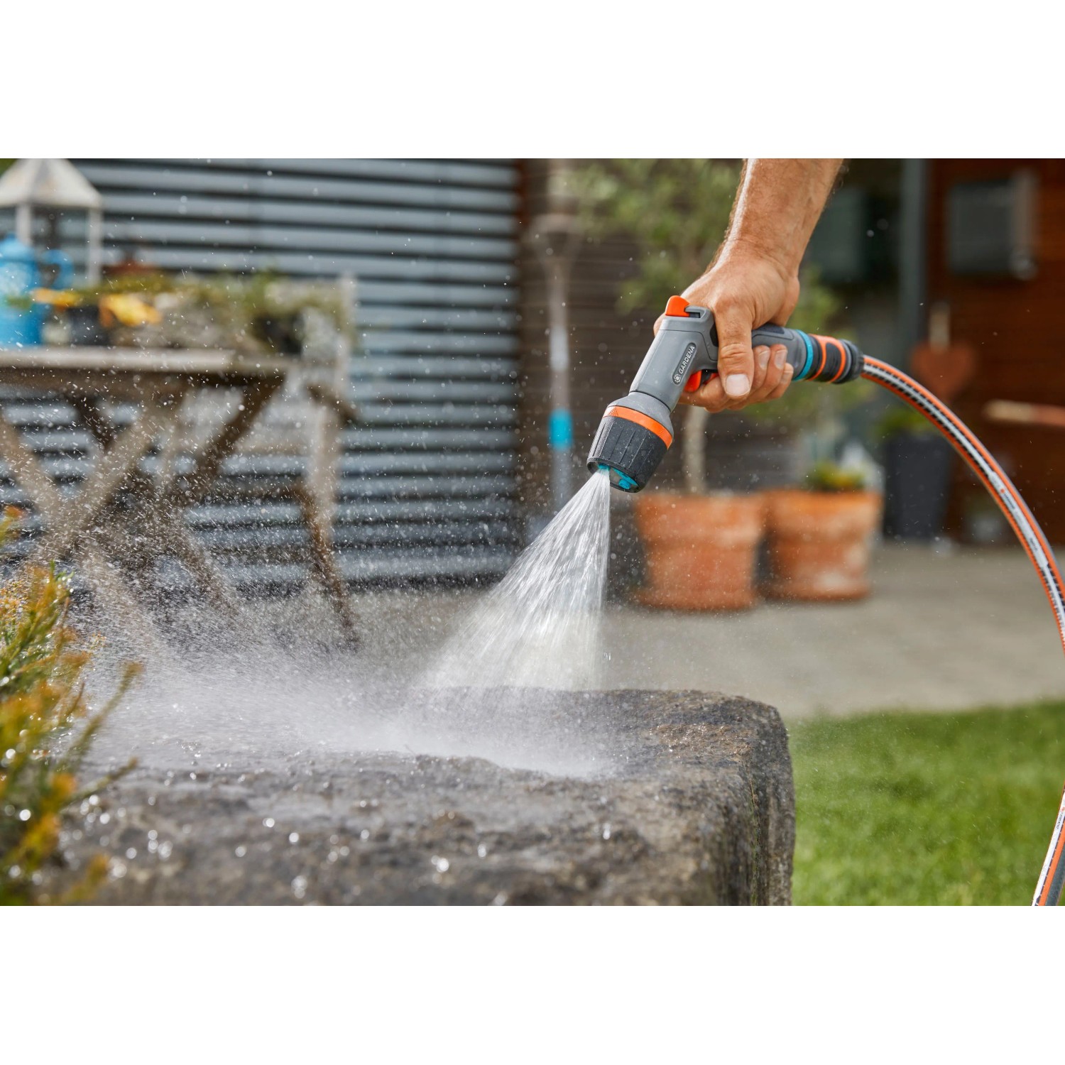 Gardena Comfort Reinigungsspritze ecoPulse™ in Aktion beim Reinigen eines Steins.