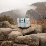 Graue Lifetime Kühlbox (26,5 Liter) mit blauem Griff und Verschlüssen auf Felsen.