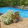 Ovaler Bestway Hydrium Stahlwandpool in Holzoptik (732x366x132cm) auf einer Holzterrasse.