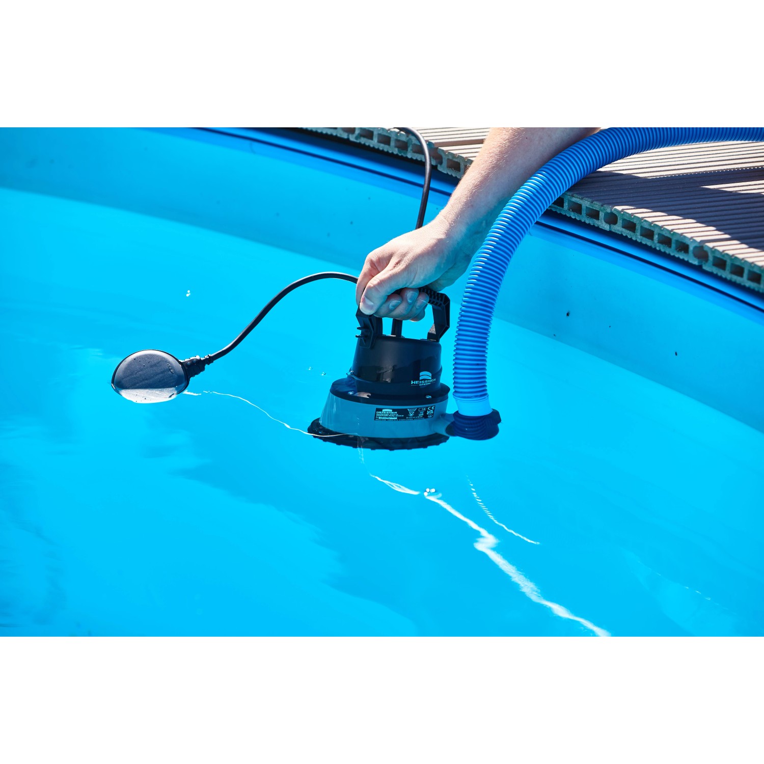 Heissner Pool-Tauchpumpe 8500 l/h im Einsatz im Pool, mit blauem Schlauch und Schwimmerschalter.