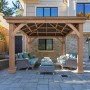 Westmann Holz Pavillon Devon 366x366 cm mit Aluminiumdach und Sitzgruppe im Garten.