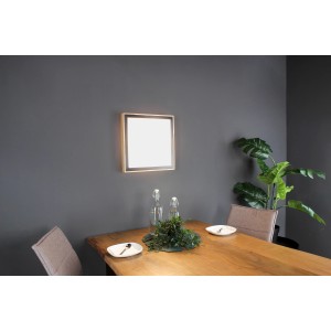 Quadratische LED-Deckenleuchte Solstar von Luce Design mit Holzrahmen, montiert an grauer Wand über Esstisch.