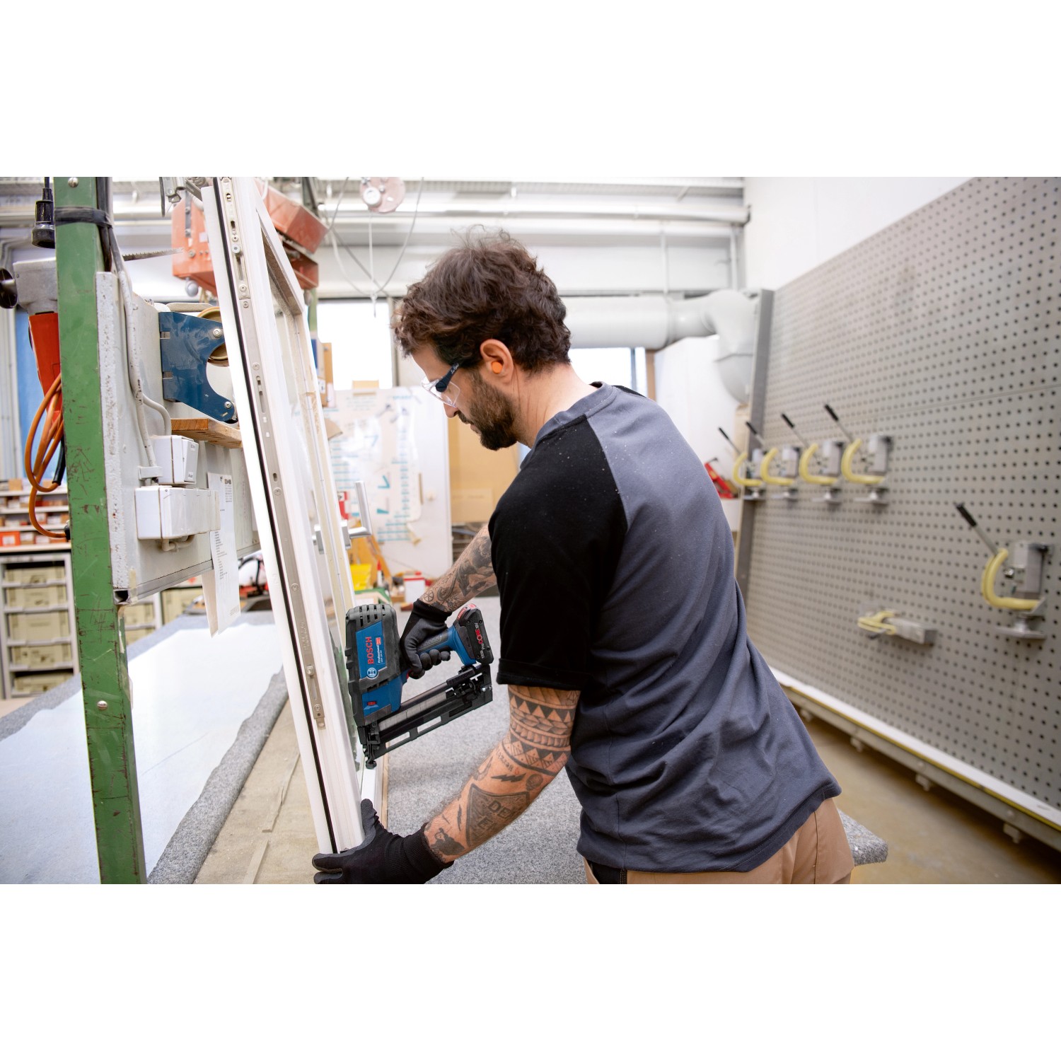 Handwerker befestigt mit dem Bosch Akku-Holznagler GNH 18V-64 M Leisten an einem Fensterrahmen.