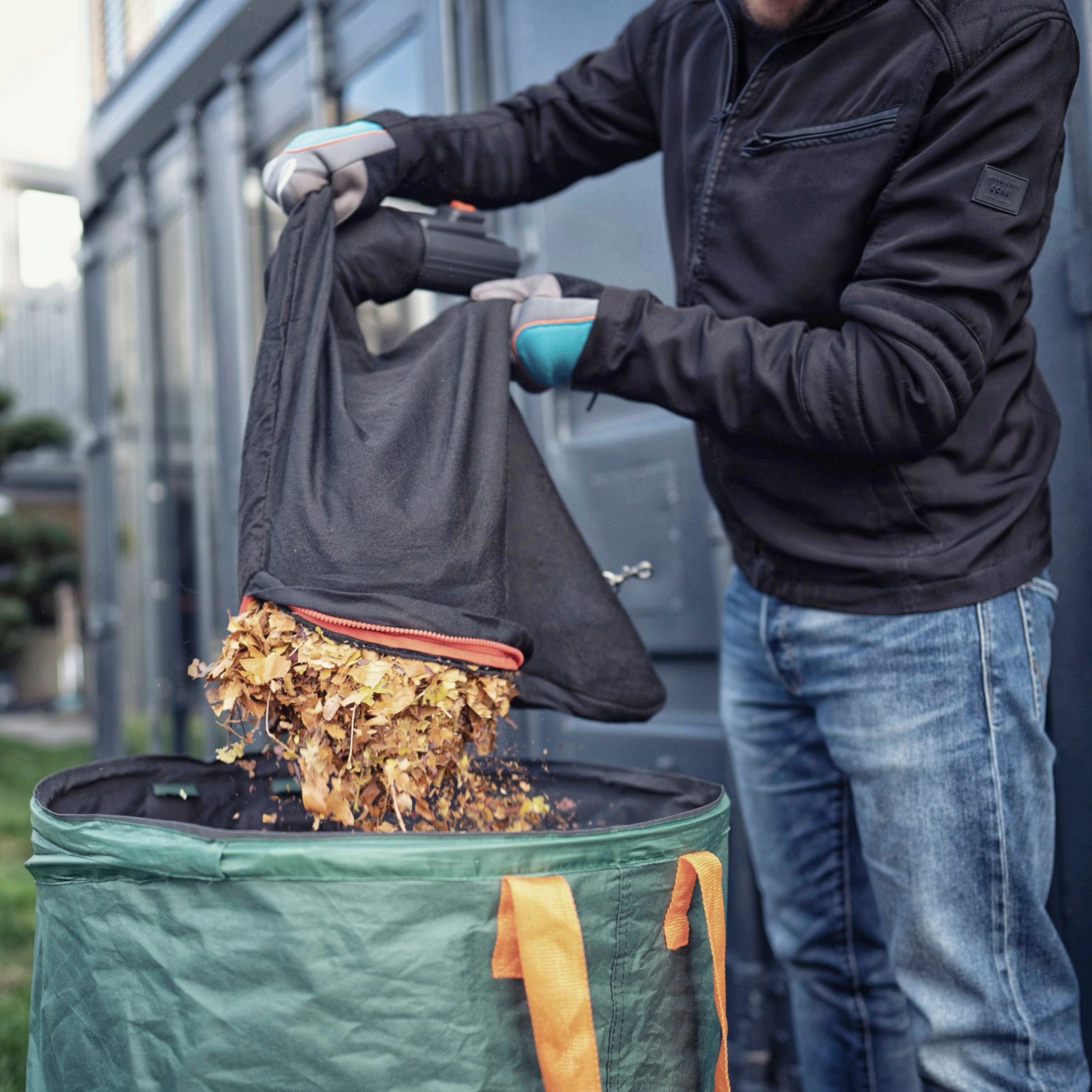 Mann leert Laubsack in Gartensack. Gardena Elektro-Laubbläser ErgoJet 3000 im Einsatz.
