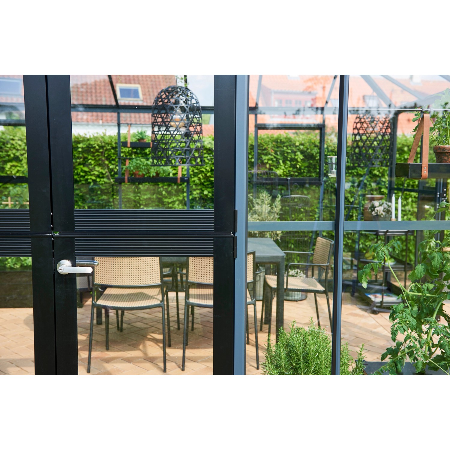 Juliana Gewächshaus Oase 8 Anthrazit, Innenansicht mit Möbeln und Pflanzen.