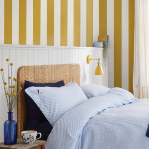 Schlafzimmer mit gelb-goldener Streifen-Tapete Joules Harborough Stripe. Vliestapete im Schlafzimmer.