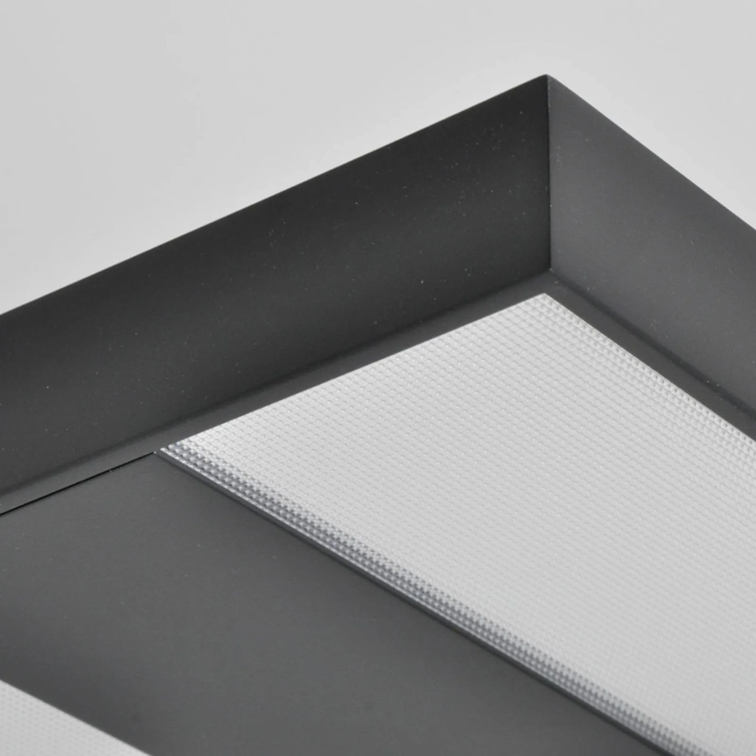 Detailaufnahme: Schwarze Arcchio LED Bürostehleuchte Logan mit Prismenstruktur.