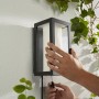Schwarze Philips Hue Impress Wandleuchte mit Farblicht, Montage im Außenbereich.