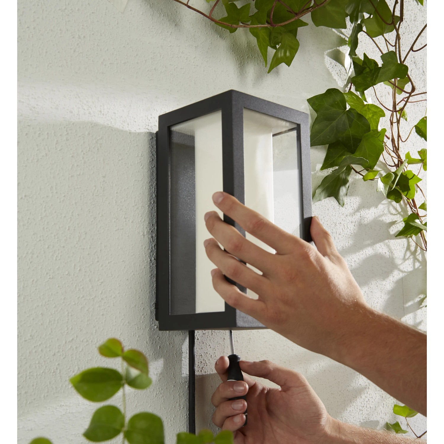 Schwarze Philips Hue Impress Wandleuchte mit Farblicht, Montage im Außenbereich.