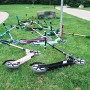 Mehrere Six Degrees Aluminium Scooter in verschiedenen Farben auf einer Wiese.