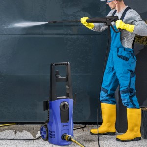 Blauer DURHAND Hochdruckreiniger mit Rollen im Einsatz vor einer Garage.