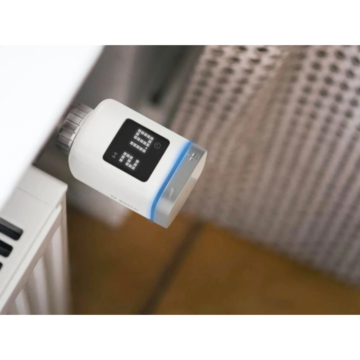 Bosch Smart Home Heizkörperthermostat II Rund am Heizkörper mit digitaler Temperaturanzeige.