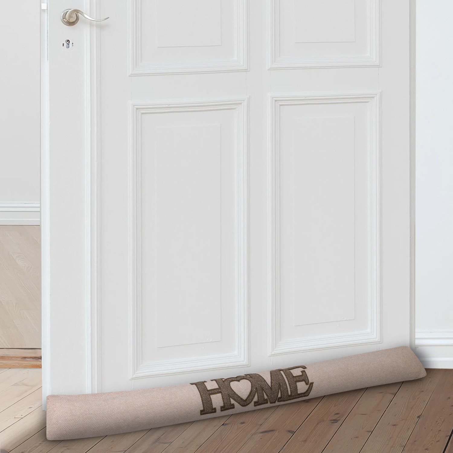 Beautissu Tuuli Zugluftstopper Natur vor weißer Tür, mit HOME Schriftzug.