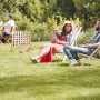 XXL Vier Gewinnt Spiel aus Holz im Garten mit entspannten Personen.