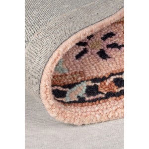 Gerollter Flair Rugs Wollteppich Blossom Schwarz-Rosa. Zeigt handgetuftete Wollschlingen mit floralem Muster in Schwarz, Rosa, Blau und Braun.