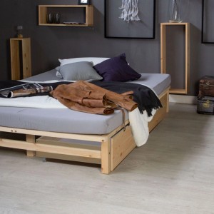 Zwei naturfarbene Homestyle4u Bettkästen aus Kiefernholz auf Rollen, teilweise unter einem Bett hervorgezogen. Praktische Aufbewahrungsboxen.