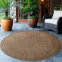 Brauner, runder Ayyildiz Outdoor-Teppich Giza 1410 (120x120 cm) auf einer Terrasse.