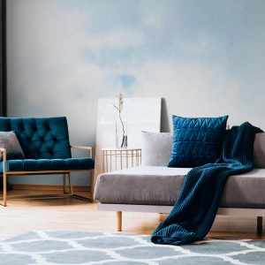 Wohnraum mit PROFHOME Fototapete Wolken in Blau-Weiß an der Wand.