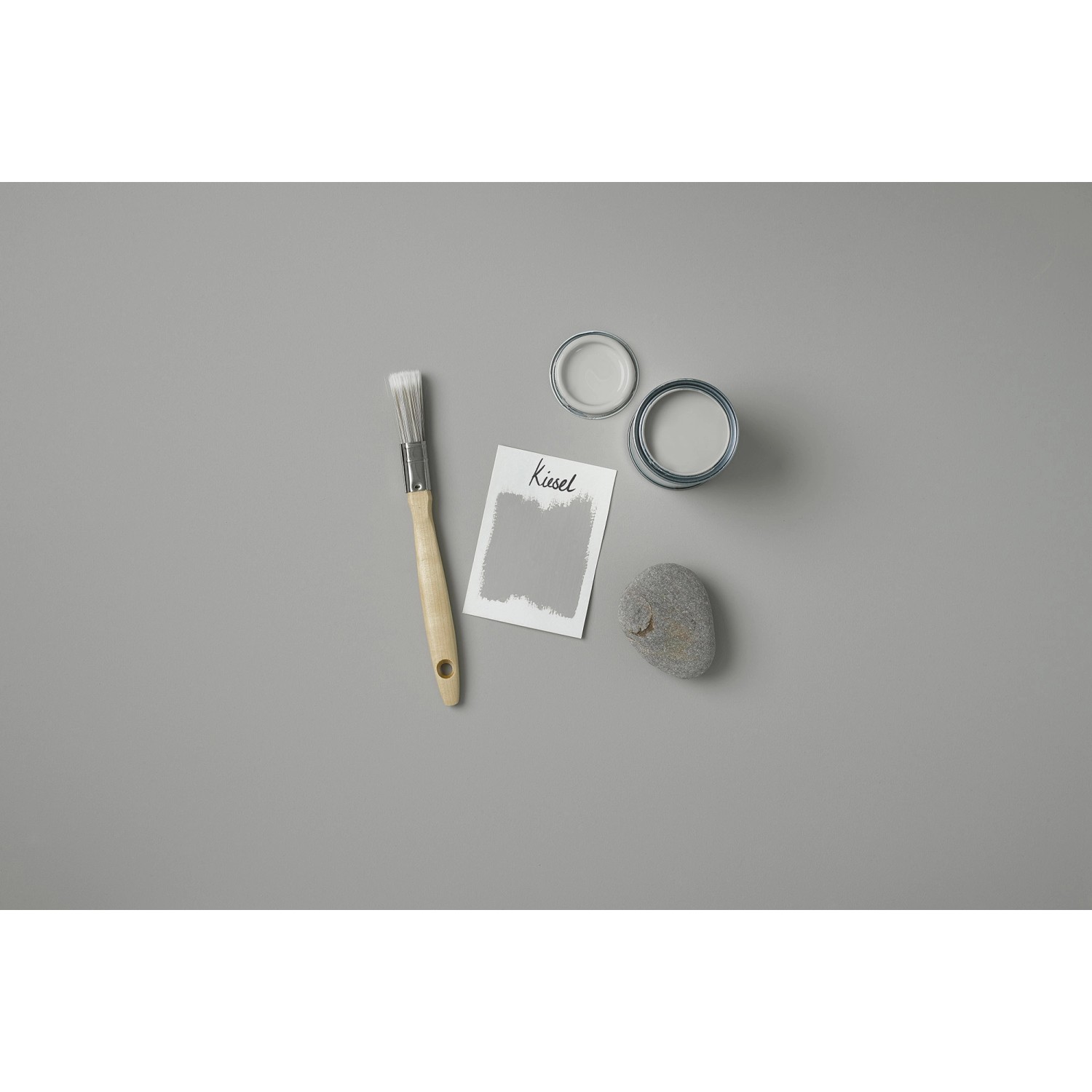 Rust-Oleum Kreidefarbe Kiesel Matt, 125ml mit Pinsel, Farbmuster und geöffneten Farbdosen.