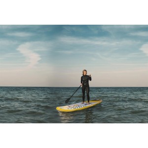 Frau auf gelbem ZRAY Stand Up Paddle Board (SUP) mit Paddel auf dem Wasser.