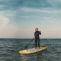 Frau auf gelbem ZRAY Stand Up Paddle Board (SUP) mit Paddel auf dem Wasser.
