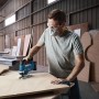 Mann sägt Holz mit Bosch Professional Akku-Stichsäge GST 18 V-125 B.
