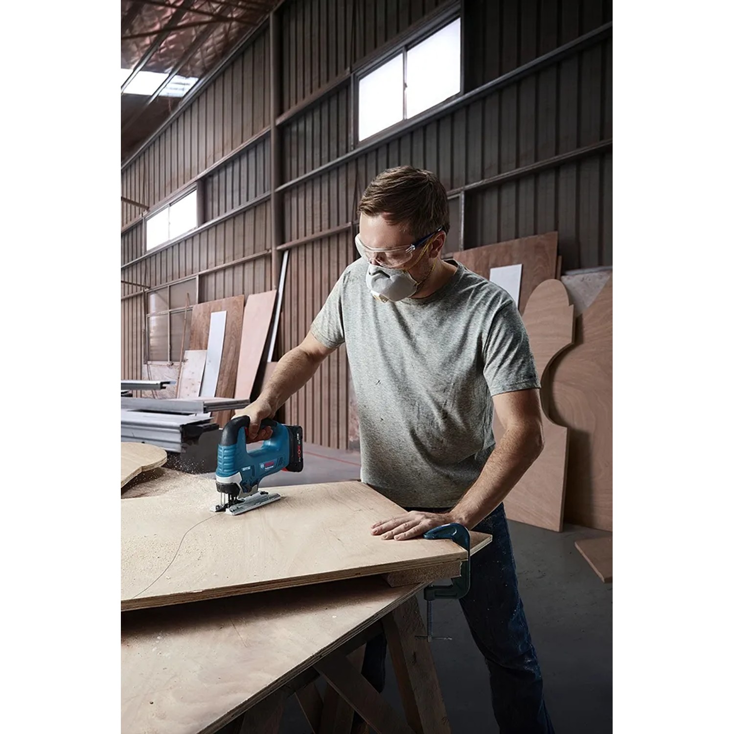 Mann sägt Holz mit Bosch Professional Akku-Stichsäge GST 18 V-125 B.