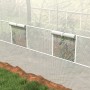 Weißes Furnicato Tunnel-Gewächshaus mit aufgerollten Netzfenstern für optimale Belüftung.