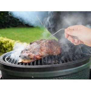 Hand steckt Funk-Fleischthermometer-Sonde in Fleisch auf rauchendem Grill. Ideal für Grillutensilien.
