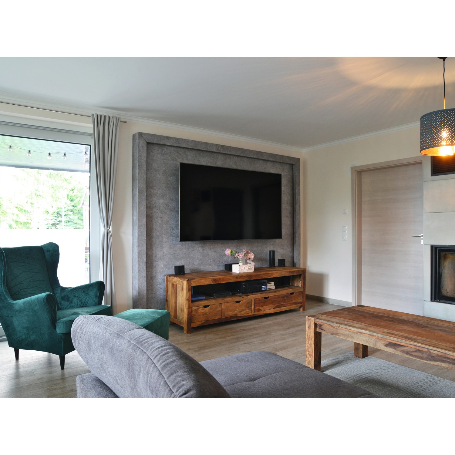 Wohnzimmer mit Egger DecoWall Rovigo Beton Wandpaneelen hinter TV-Möbel.