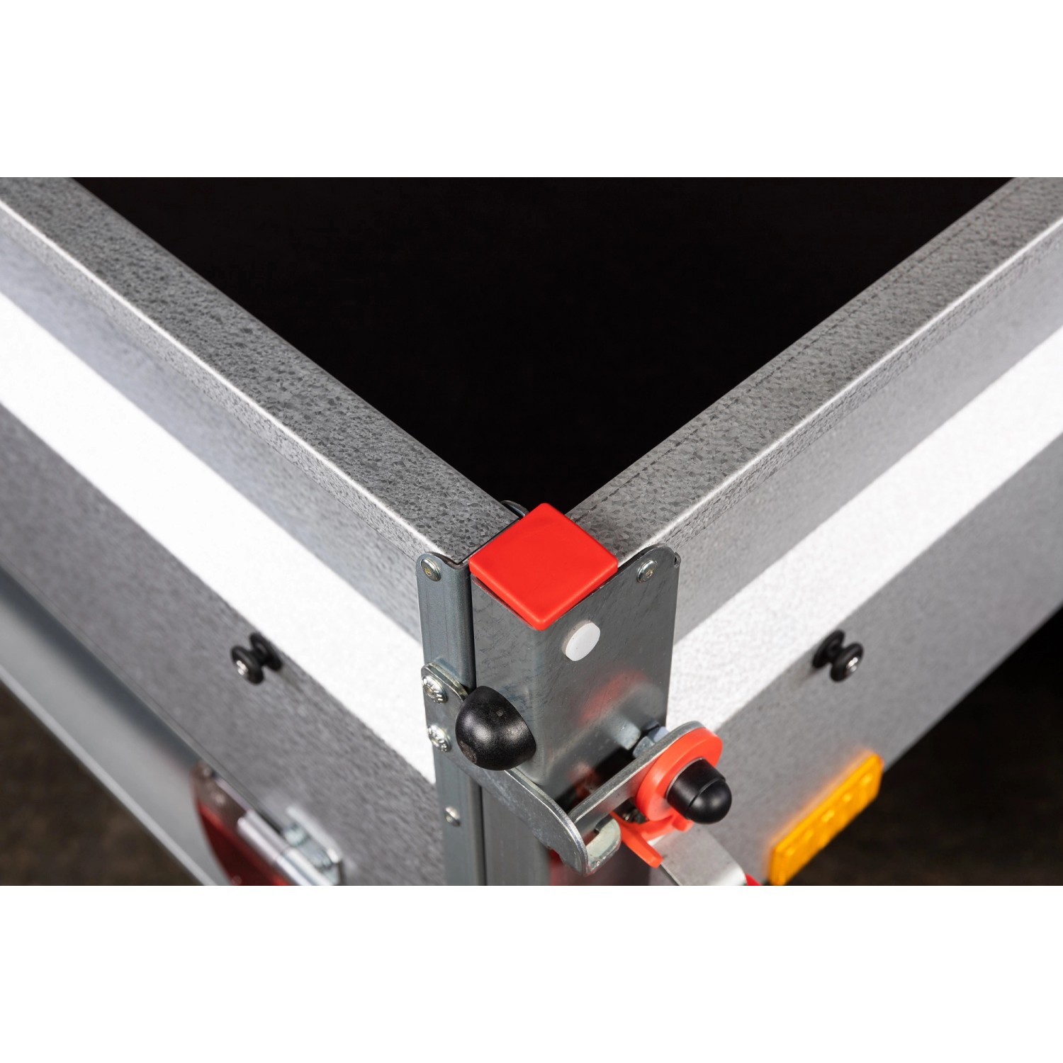 Detailansicht Stema Anhänger Basic 750: Bordwand, Verschluss und rote Eckschutzkappe.