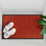 Rote Karat Schmutzfangmatte Rhine 90x150 cm mit schwarzen Rand und Schuhen.