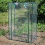 Floraworld Gewächshaus 5 m² mit Folie und grünem PVC-Rahmen im Garten.