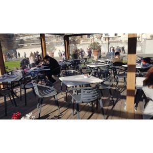 Café-Szene mit graubraunen Papatya Mambo Sesseln und Tischen im Außenbereich.