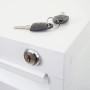 Nahaufnahme: Weißer Aktenschrank aus Stahl mit Zylinderschloss und zwei Schlüsseln. Sicherer Büroschrank.