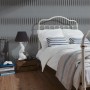 Strukturprofiltapete Streifen Silber im Schlafzimmer mit Bett und Lampe.