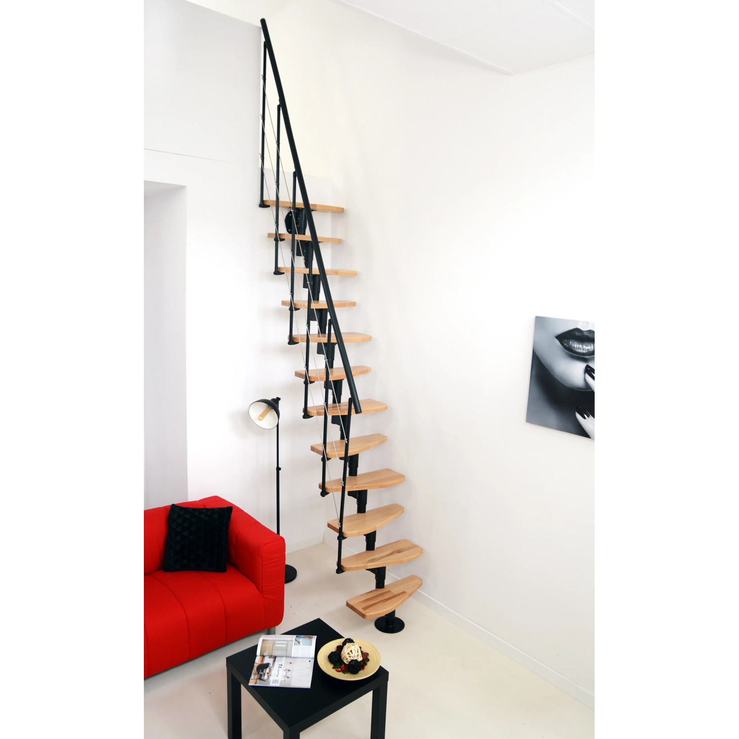 Minka Raumspartreppe Nizza Buche/Schwarz, gerade Treppe mit Buchenholzstufen und schwarzem Geländer im Wohnraum.