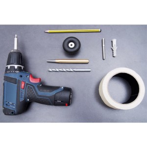 Wagner Bodentürstopper EH5201 Schwarz mit Werkzeug und Zubehör auf grauem Untergrund.