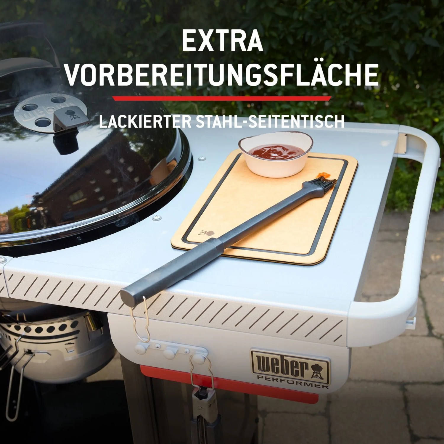 Detailansicht Weber Holzkohlegrill Performer 57 cm: Seitentisch mit Schneidebrett und Soße.