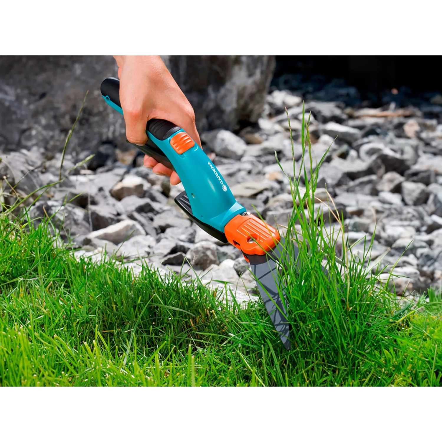 Gardena Comfort Grasschere im Einsatz: Hand schneidet Rasenkante präzise. Drehbare Klinge für Links- und Rechtshänder.