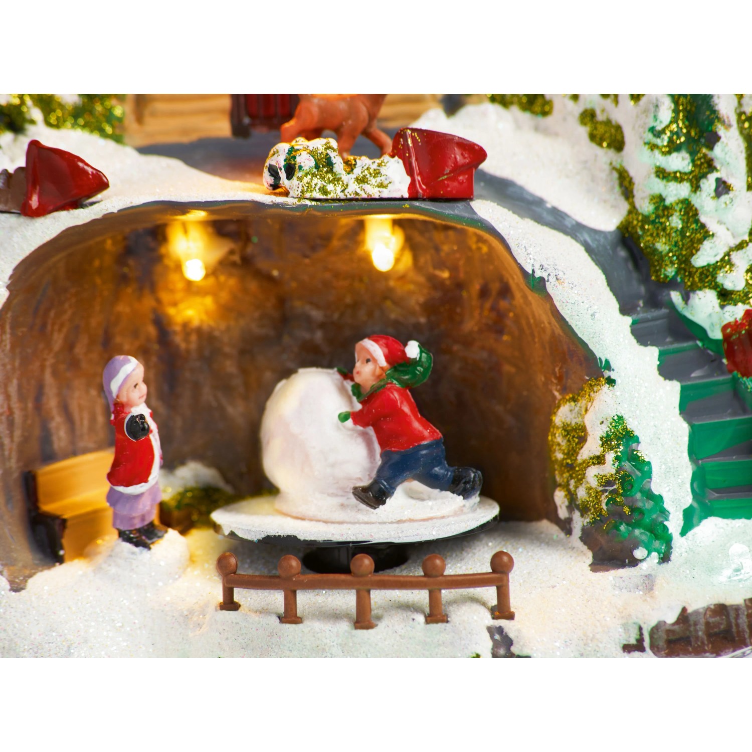 Beleuchtete OBI Weihnachtsdorf Figur: Kinder rollen Schneeball in verschneiter Ski Landschaft mit Glitzer.