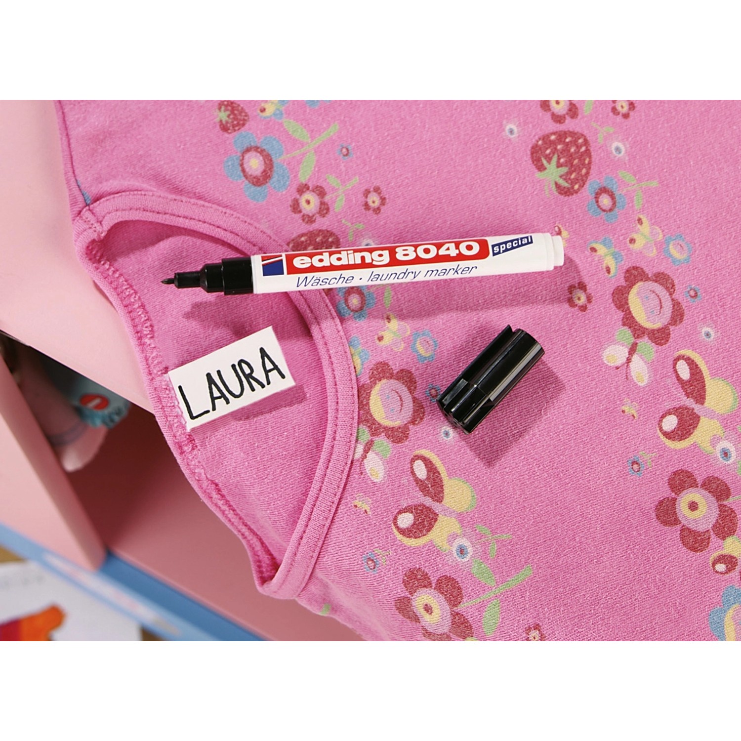 Edding 8040 Wäschemarker schwarz auf rosa T-Shirt mit Namensetikett.