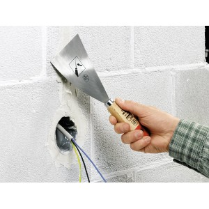 Hand hält LUX Malerspachtel (100mm) zum Glätten von Spachtelmasse an einer Wand.