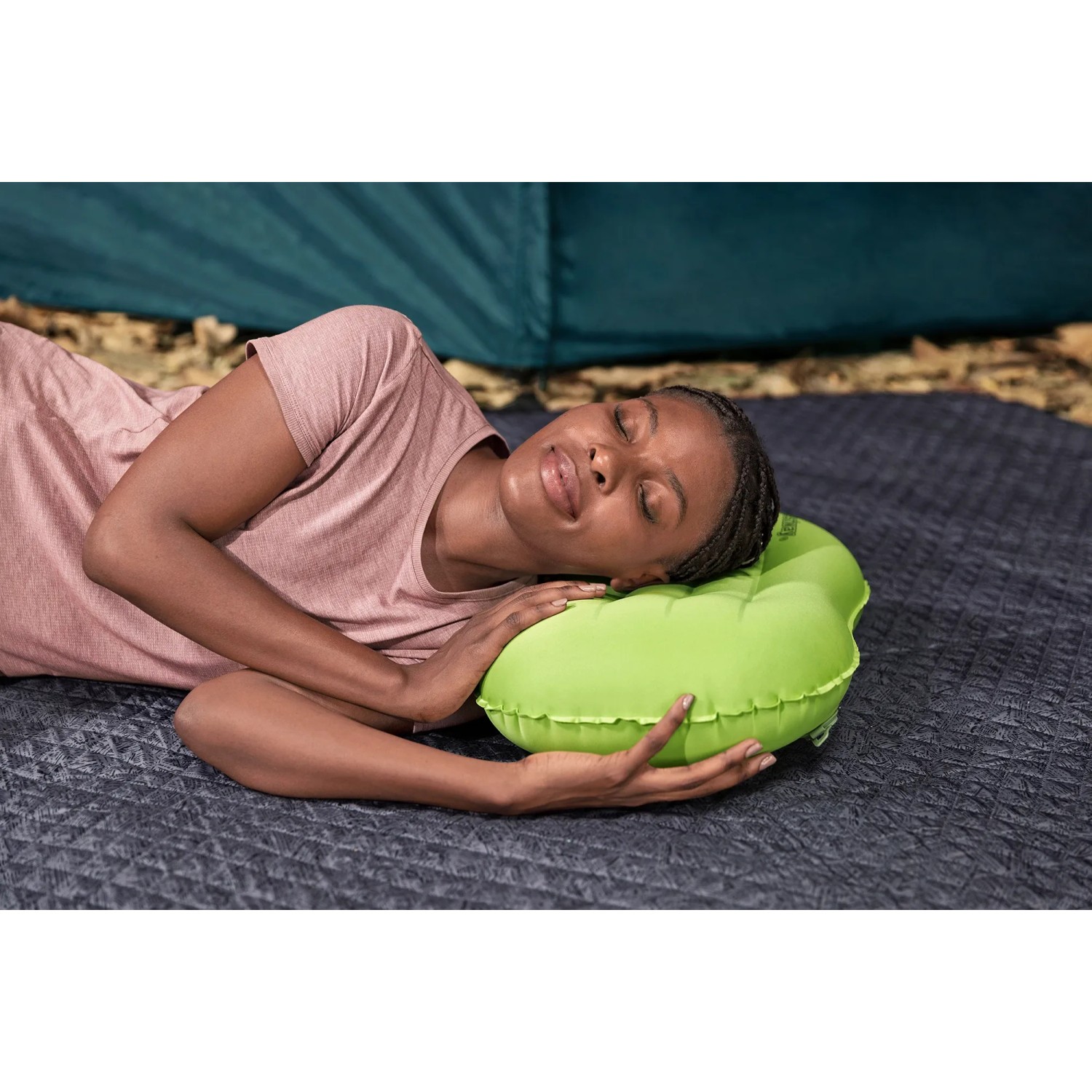 Frau ruht auf grünem Bestway Air Pillow Wanderlite Camping-Kissen.
