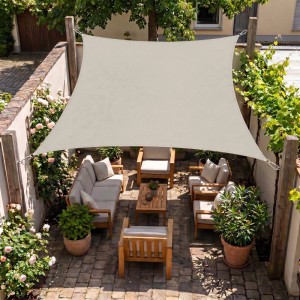 Rechteckiges Sunula Sonnensegel in Taupe über einer Terrasse mit Holzmöbeln. Bietet UV-Schutz und Schatten für den Garten.
